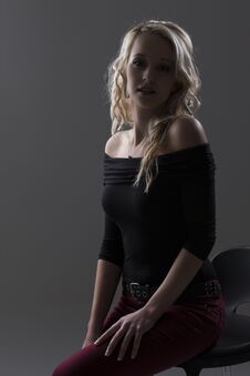 Beautiful Blond Woman In Curly Hair And Black Top And Red Pants Stock Photos