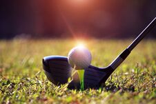 Blurred Golf Club And Golf Ball Close Up In Grass Field With Sun Stock Photo