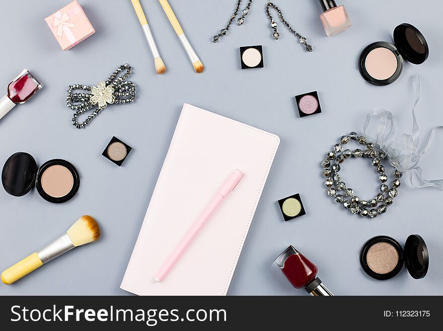 Beauty, fashion blogger concept. Fashion accessories, note book and cosmetics on grey background flat lay. Top view