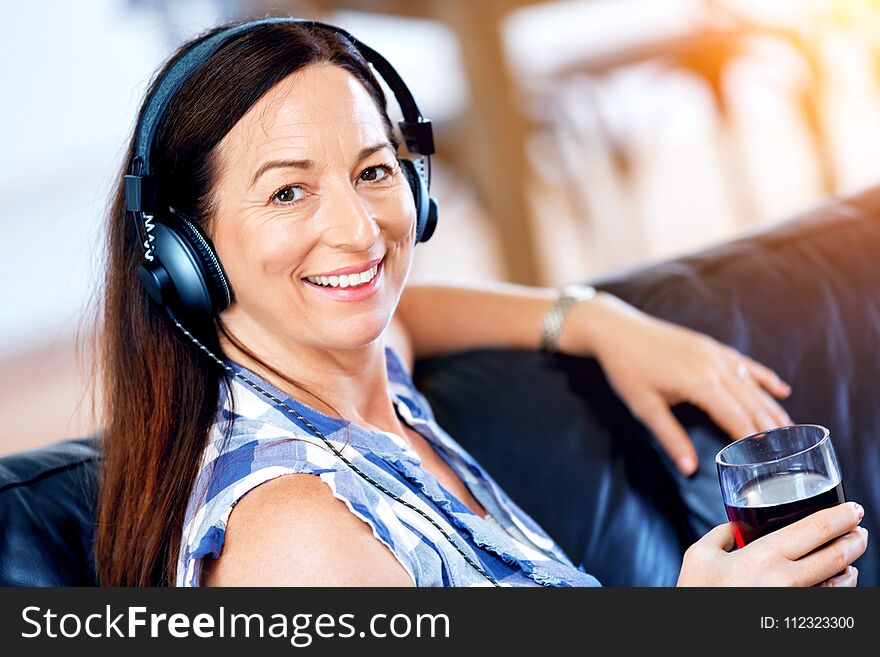 Happy smiling woman relaxing and listening to music with headphones