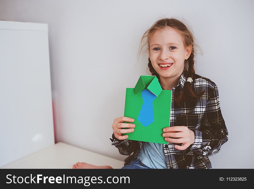 Happy child girl making greeting card for gift for Fathers Day.