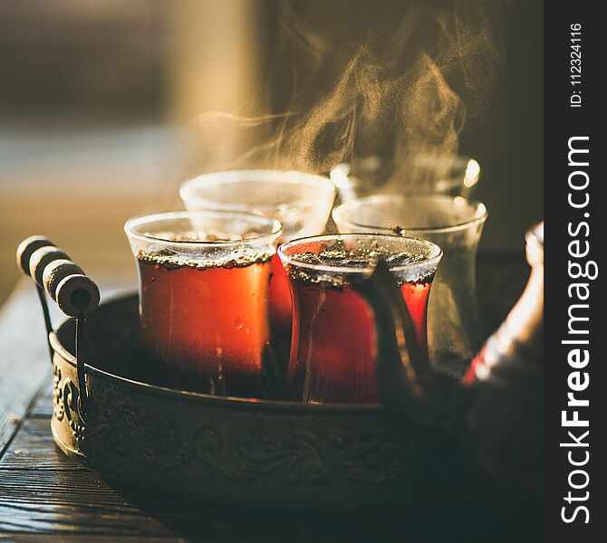 Freshly brewed black tea in turkish glasses in oriental tray, selective focus, copy space, square crop. Freshly brewed black tea in turkish glasses in oriental tray, selective focus, copy space, square crop