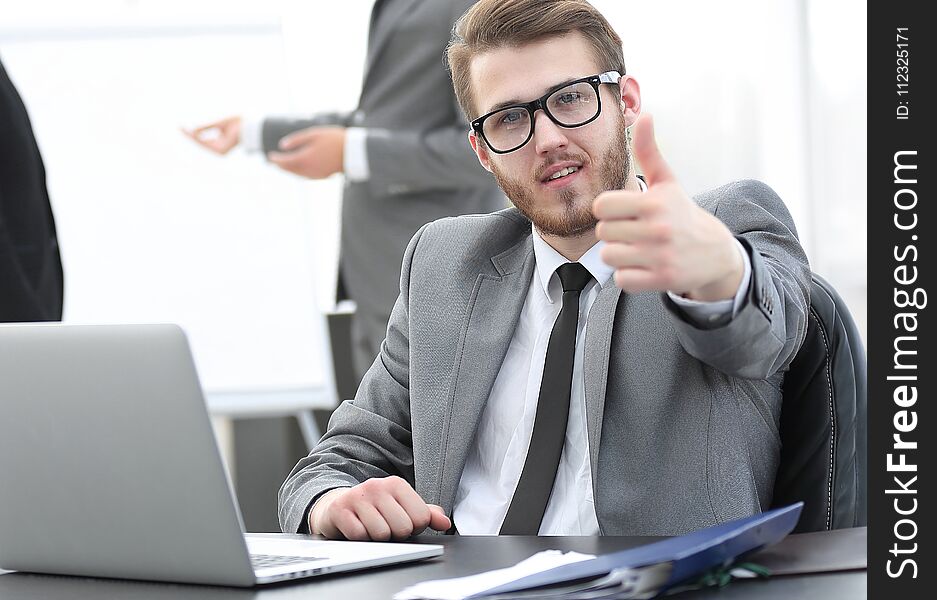 Businessman sitting at his Desk and showing thumbs up. Businessman sitting at his Desk and showing thumbs up