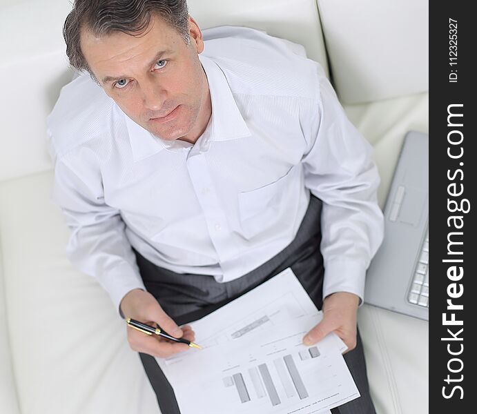 Closeup.the view from the top.businessman working with documents sitting on sofa