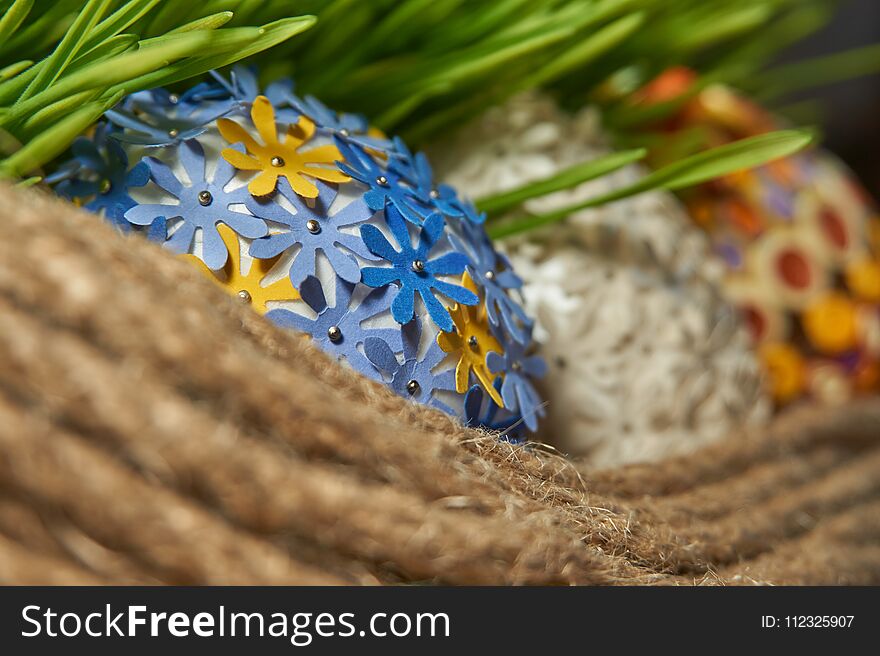 The Easter egg decorated with multicolored paper, placed between frech green wheat germs and jute rope. Easter Craft Ideas. The Easter egg decorated with multicolored paper, placed between frech green wheat germs and jute rope. Easter Craft Ideas.
