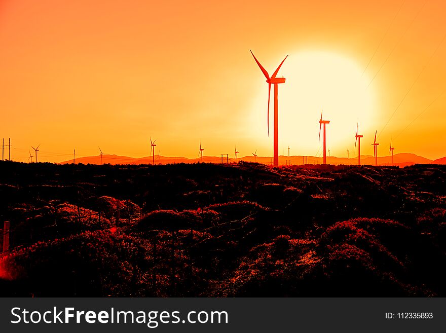 Wind turbines at orange sunrise