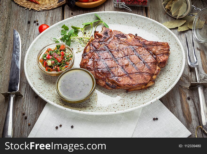 Tenderloin steak on plate with sauce, on a wooden table