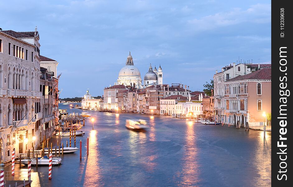 Venice cityscape at night with Grand Canal and Basilica Santa Maria della Salute, Italy.
