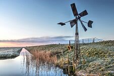 Windmill By The Side Of A Ditch Stock Photo