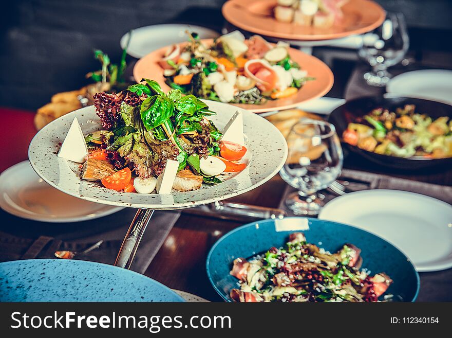 Many different dishes in Restaurant, white plate on the Table with side dish, cracker