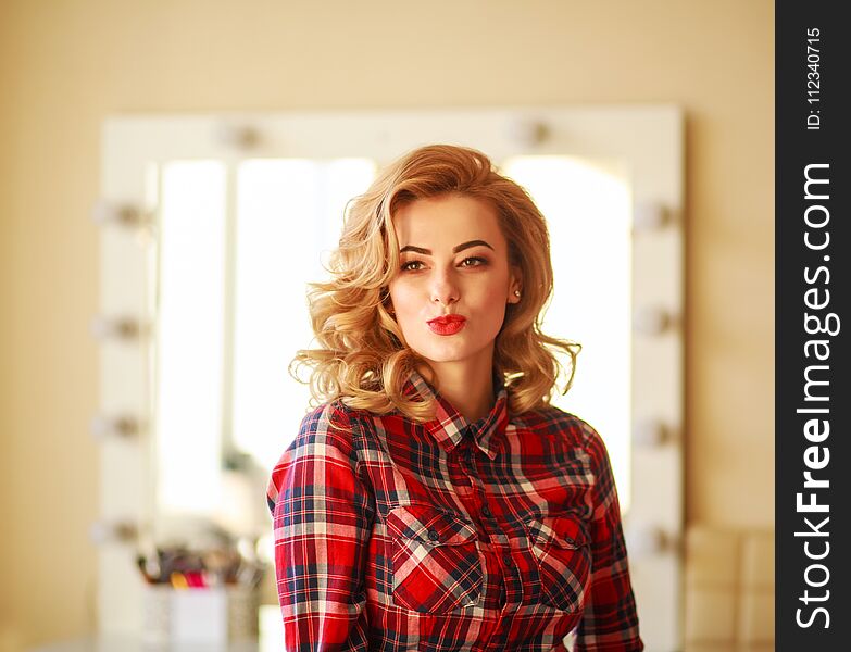 Gorgeous woman try on makeup in the mirror in the home studio of beauty