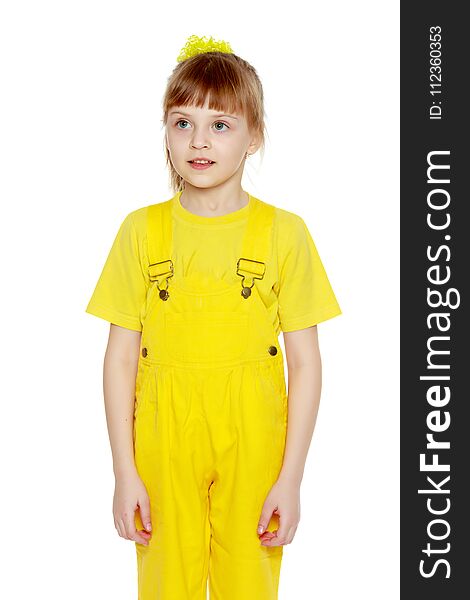 Girl with a short bangs on her head and bright yellow overalls.