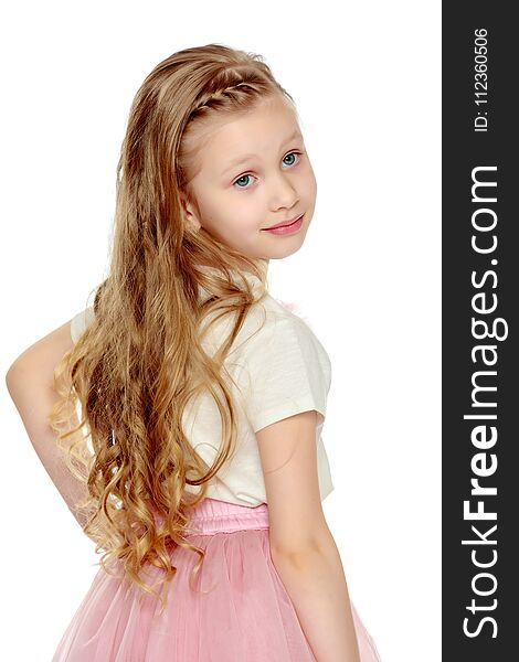 Beautiful little blonde girl with long hair.In a lush short pink skirt and white T-shirt.Turning his back to the camera.Isolated on white background. Beautiful little blonde girl with long hair.In a lush short pink skirt and white T-shirt.Turning his back to the camera.Isolated on white background.