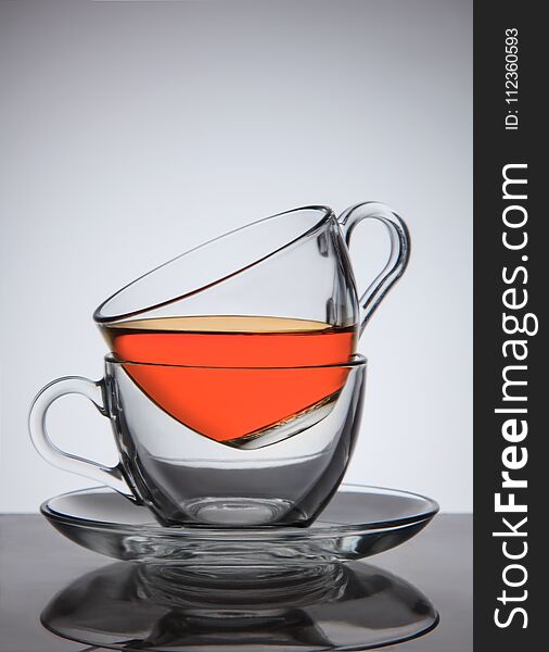 Glass cups of tea on saucer, good concept the idea, on grey gradient background.