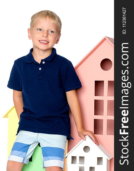 A little boy is playing with colorful houses.