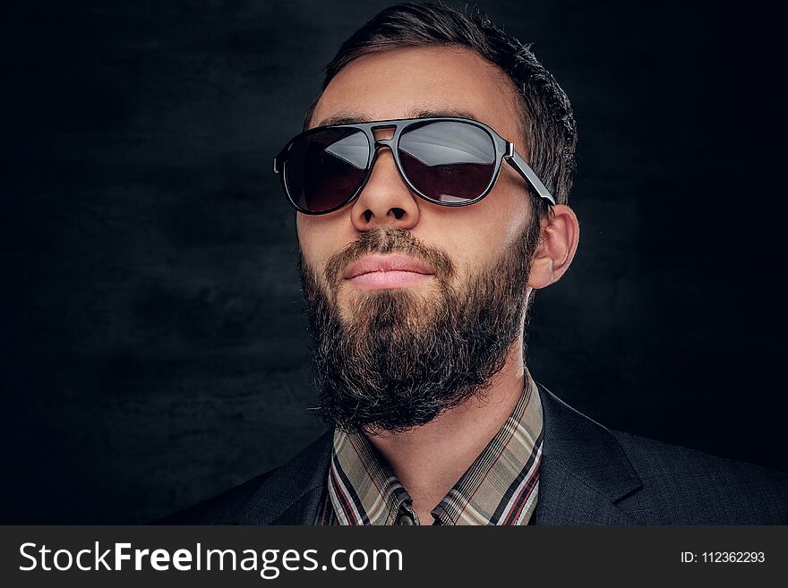 Close up portrait of bearded male in sunglasses on grey vignette background. Close up portrait of bearded male in sunglasses on grey vignette background.