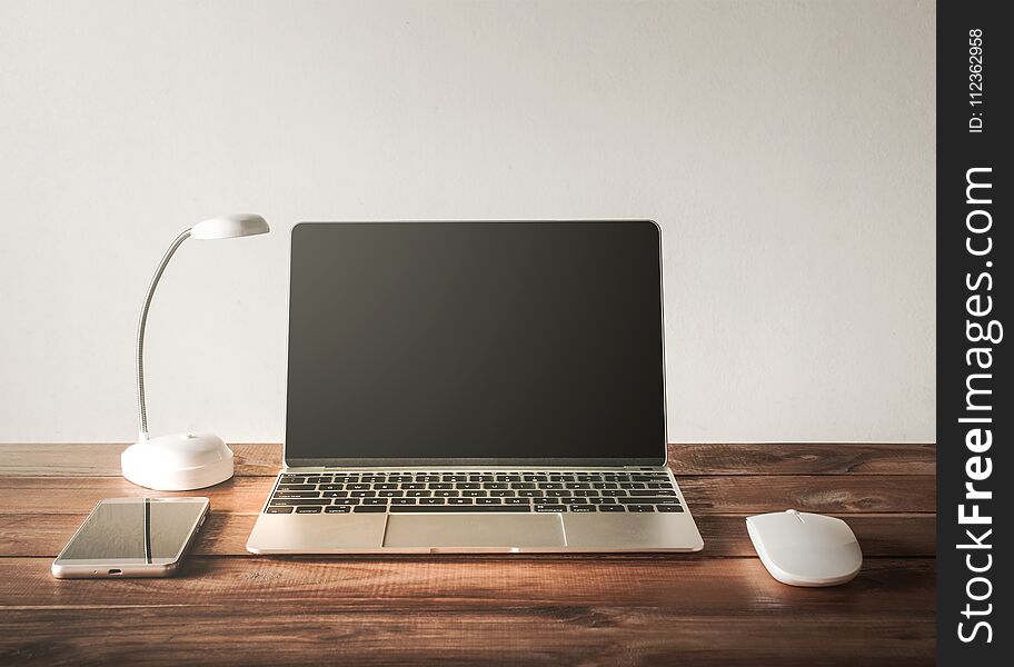 Blank screen Laptop, mobile phone, mouse, on work table .