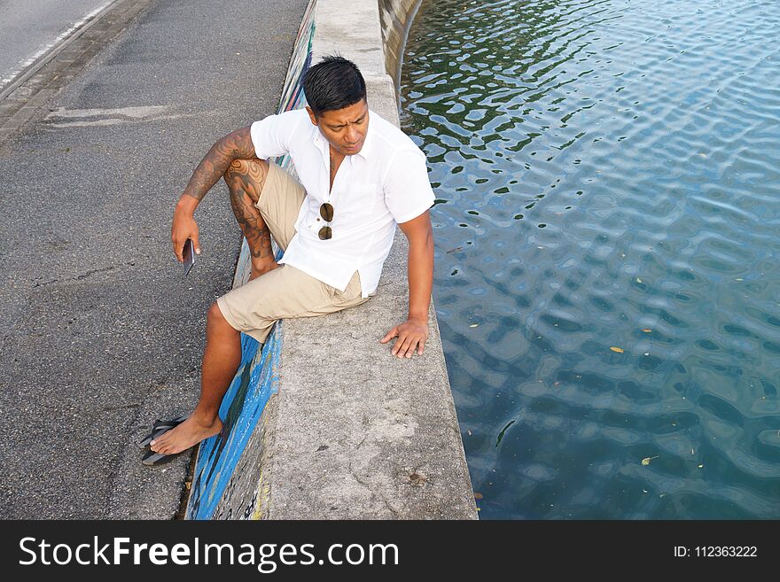 Man on seawall on vacation in Japan with white shirt 1