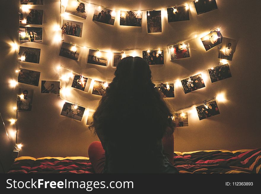 Woman Watching Photo Collection With String Lights
