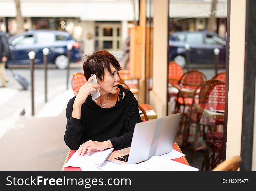 female client of co-working working at table with laptop and make purchases by credit card. Aged lady sitting near desk littered with papers glasses laying on sheet. Woman hold card and enters payment information in computer. Concept of easy shopping with gadgets and internet. female client of co-working working at table with laptop and make purchases by credit card. Aged lady sitting near desk littered with papers glasses laying on sheet. Woman hold card and enters payment information in computer. Concept of easy shopping with gadgets and internet.