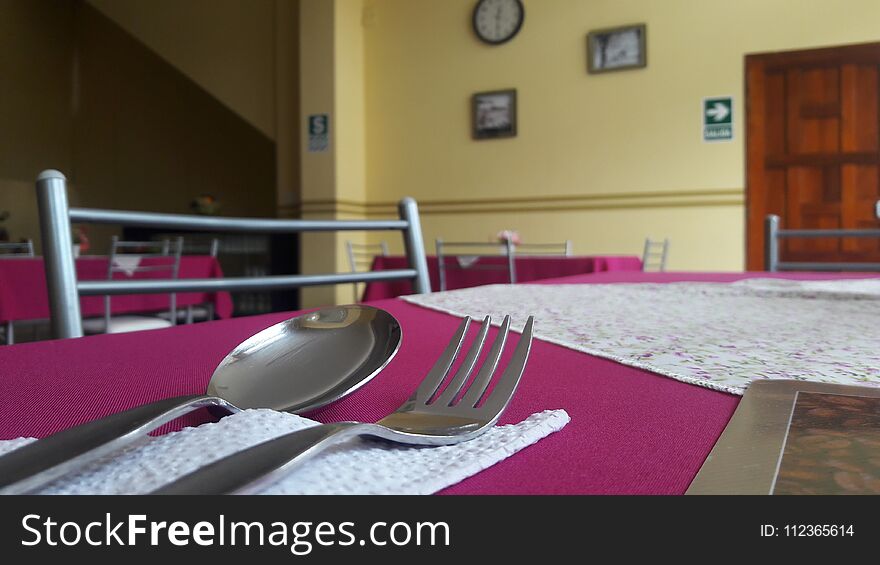 A spoon and a fork over a dining table of a restaurant in Peru.