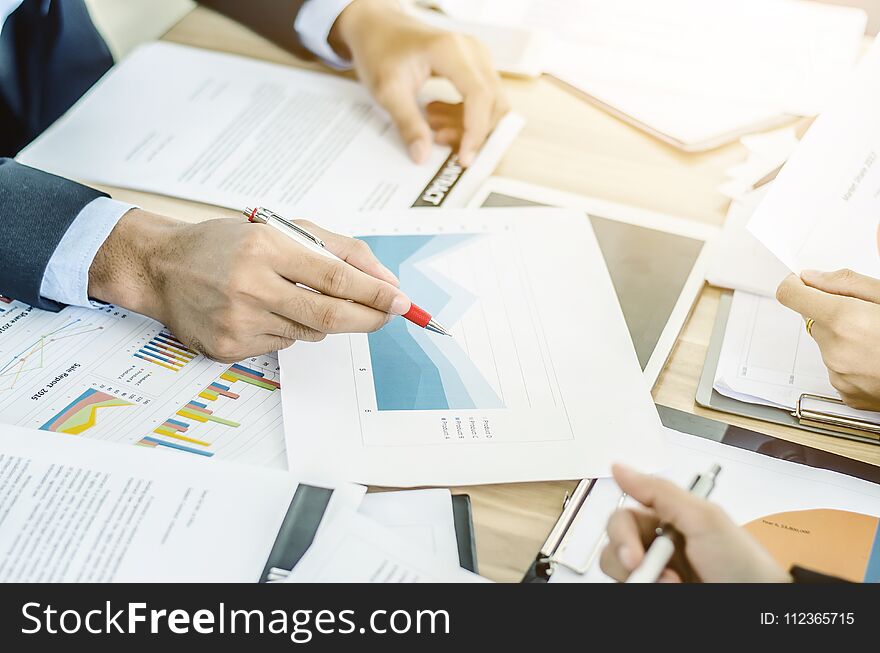 Close-up of business team using pen with financial diagram and digital tablet