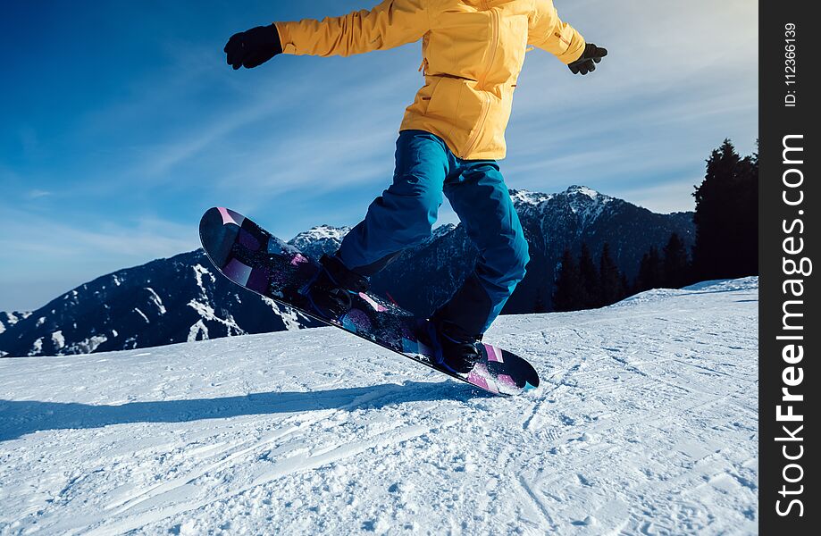 Snowboarder snowboarding in winter mountains