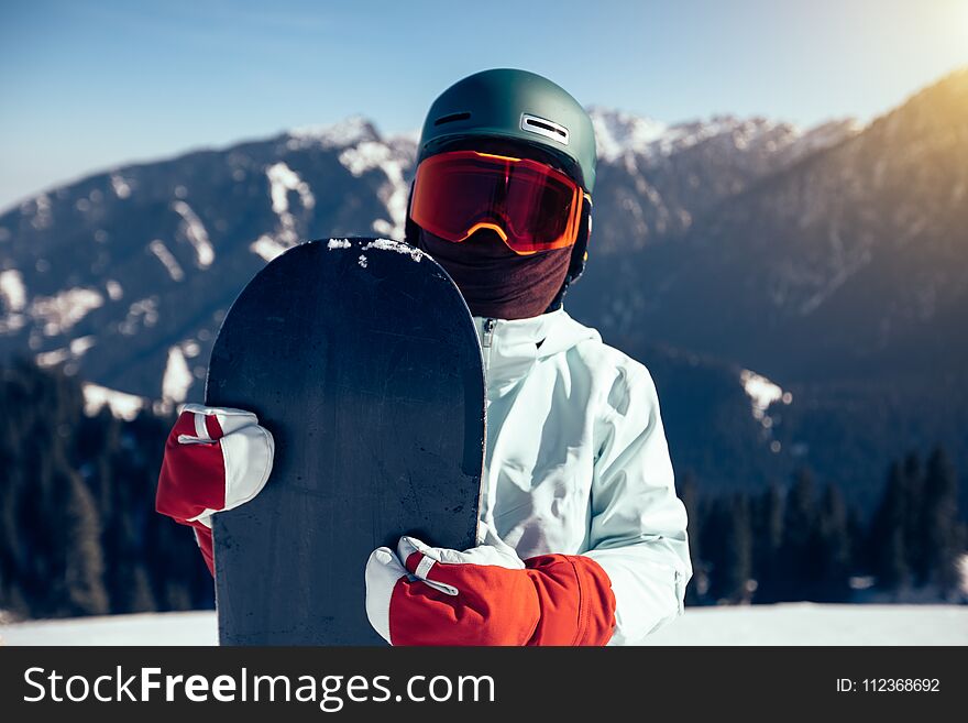 Snowboarder with snowboard on winter mountain top