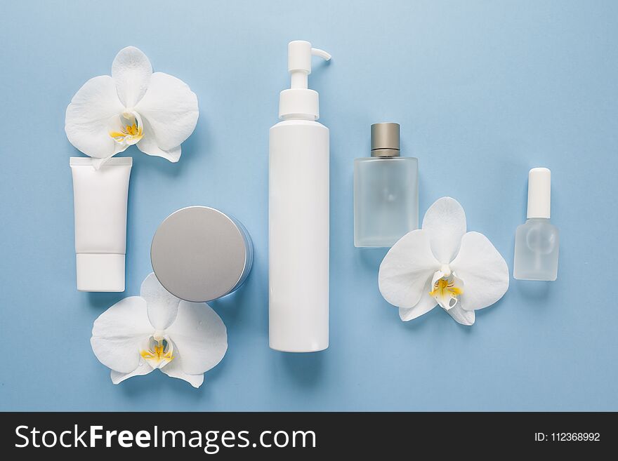 Cosmetic bottle containers with white orchids, Blank label for branding mock-up, Natural beauty product concept. Cosmetic bottle containers with white orchids, Blank label for branding mock-up, Natural beauty product concept.