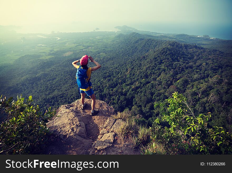 Woman hiker shouting on mountain peak cliff edge