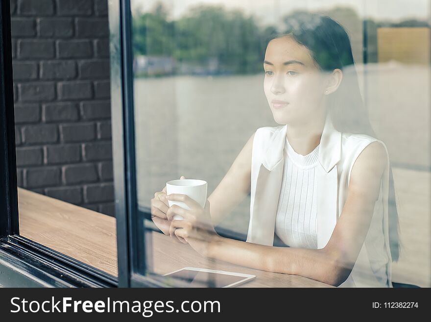 Young woman drinking relaxing coffee in coffee shop