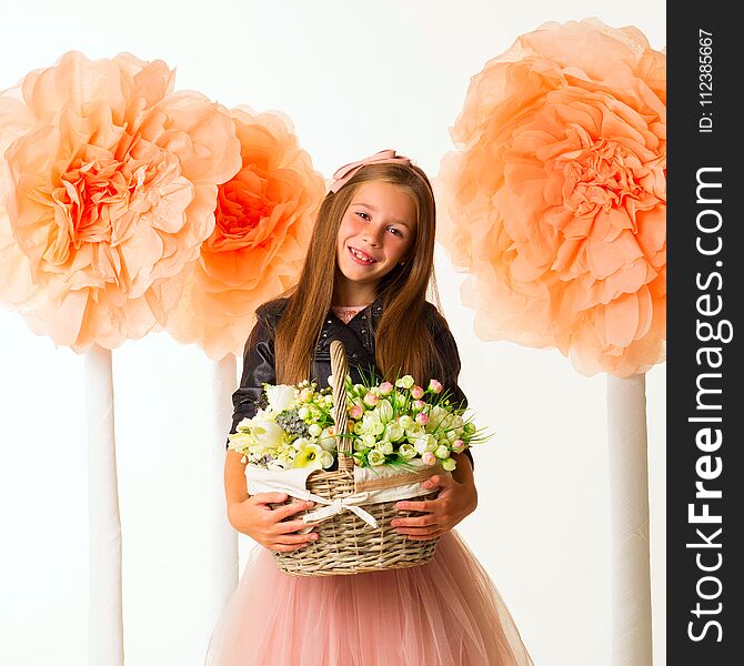 Young Beautiful Little Girl With Basket Of Flowers In Leather Jacket Over White Background