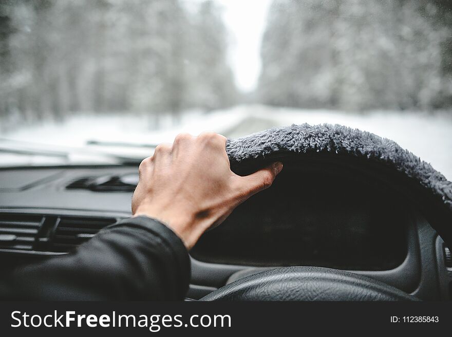 Hand on the helm. Driving in the winter forest
