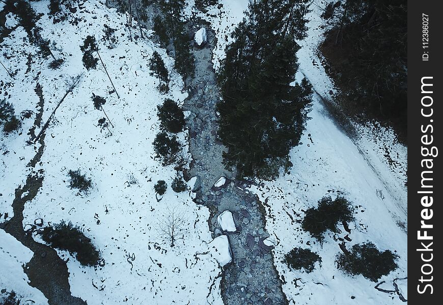 River without water in a frozen valley, aerial view