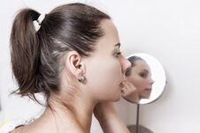 Beautiful Young Woman In Front Of Round Mirror. Attractive Girl Doing Makeup At Home Royalty Free Stock Photos