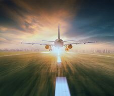 Air Plane Flying Over Airport Runway With City Scape And Sunset Royalty Free Stock Photos