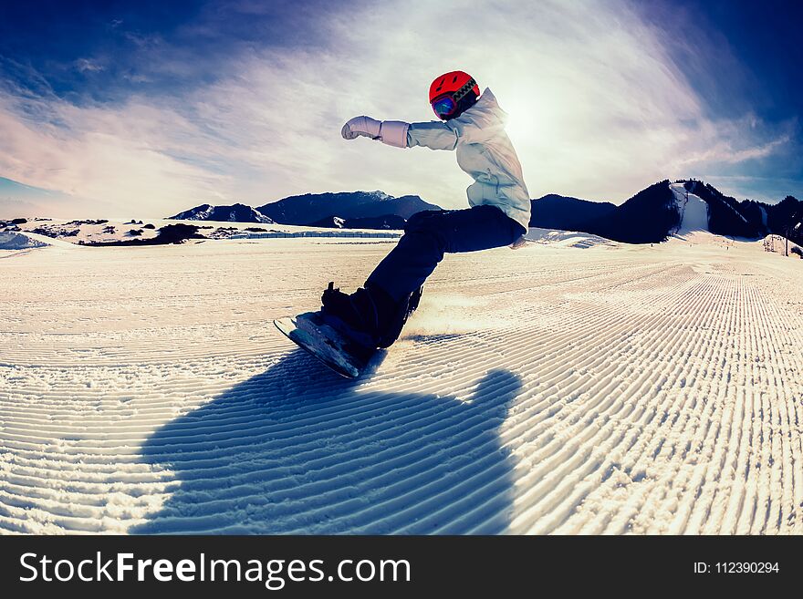 Snowboarding on winter mountain top slope