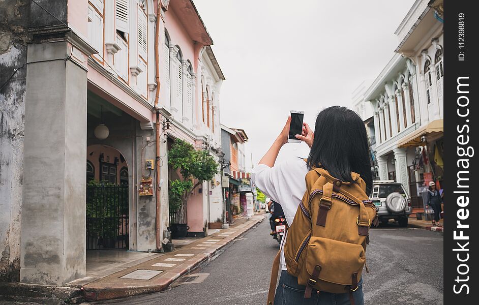 Traveler backpacker use mobile phone taking photo of old town ci