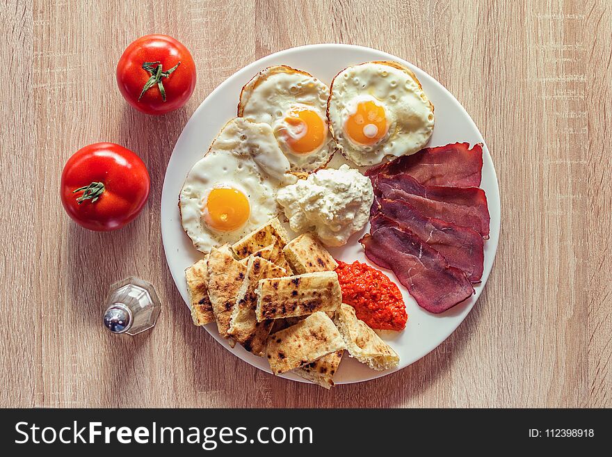 Traditional Serbian breakfast with eggs, ham, cheese, ajvar and homemade bread