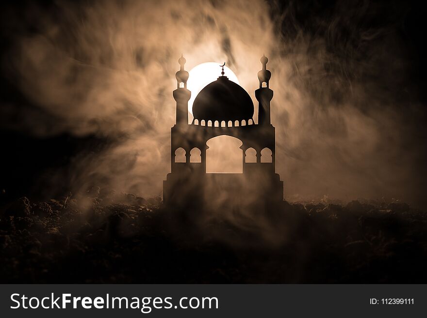 Silhouette of mosque building on toned foggy background. Ramadan Kareem background. Mosque at sunset. Praying people. Selective fo