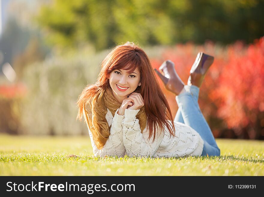 Young pretty woman relaxing in the park. Nature beauty, colorful field with flowers. Outdoor lifestyle. Freedom concept. Woman in summer field