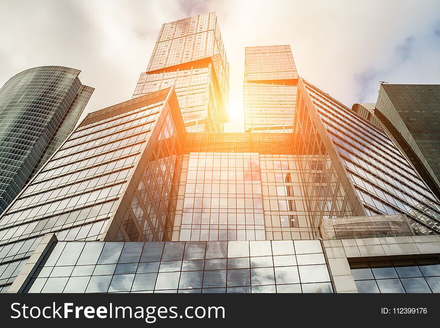 Detail blue glass modern office building background with cloud sky and sunlight. Detail blue glass modern office building background with cloud sky and sunlight