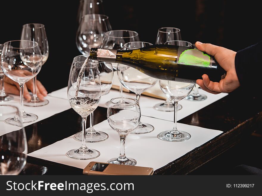 Sommelier At Wine Tasting Pouring Wine From A Bottle Into Glass At Wine Tasting