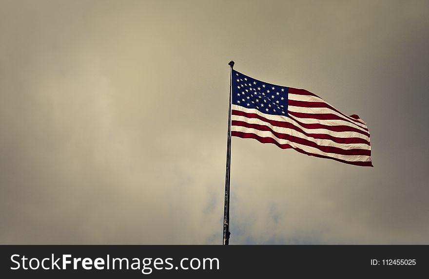 Photo of Cloudy Skies over American Flag