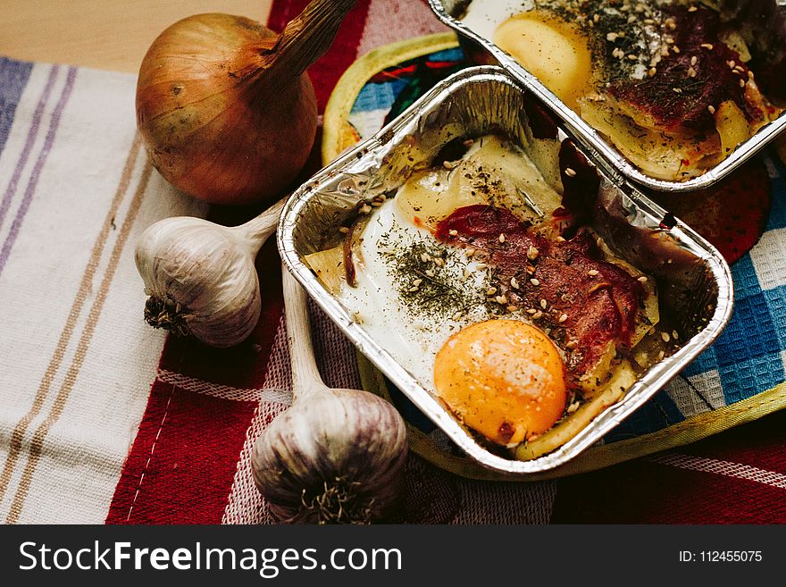 Cooked Food in Square Grey Tray Beside Garlics and Onion