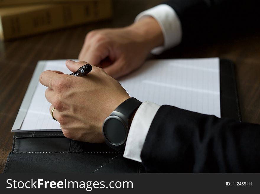 Person on Black Suit Jacket Writing on White Paper