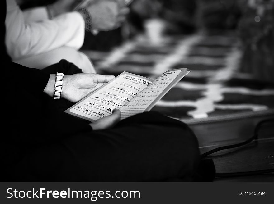 Grayscale Photography of a Person Holding Book