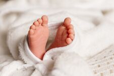 Bare Feet Of A Cute Newborn Baby In Warm White Blanket. Small Bare Feet Of A Little Baby Girl Or Boy. Sleeping Newborn Royalty Free Stock Photos