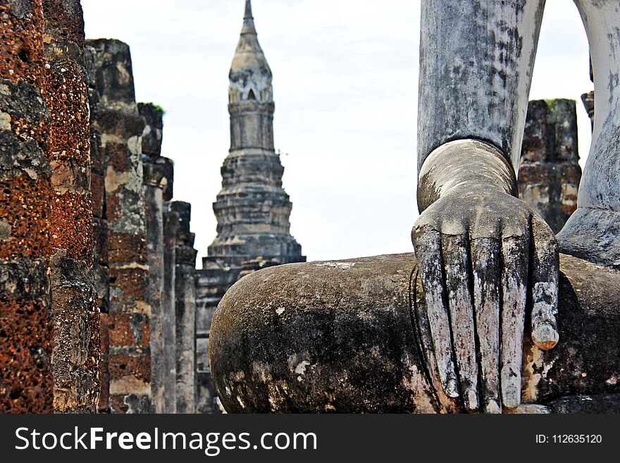 Hand Of Old Buddha Image And Temple Background At Sukhothai Thailand