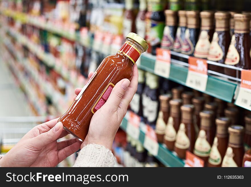 Buyer Hands With Bottle Of Sauce In Store